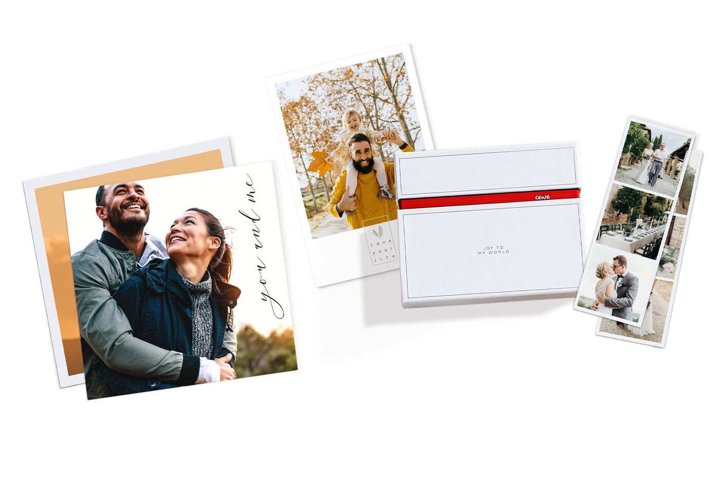 Due cartoline fotografiche personali e un libro fotografico CEWE su un tavolo bianco.